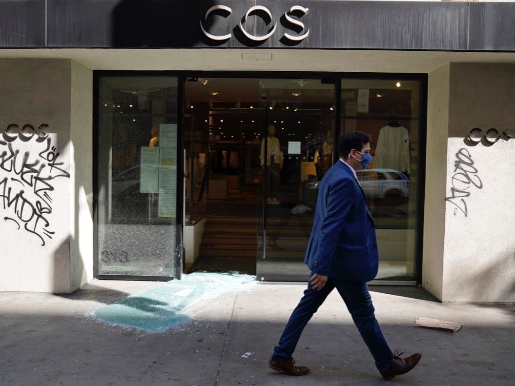 A pedestrian walks past a COS clothing store that was looted and vandalized during last night's fan celebrations following the Los Angeles Dodgers' World Series win, Wednesday, Oct. 28, 2020, in Los Angeles. 