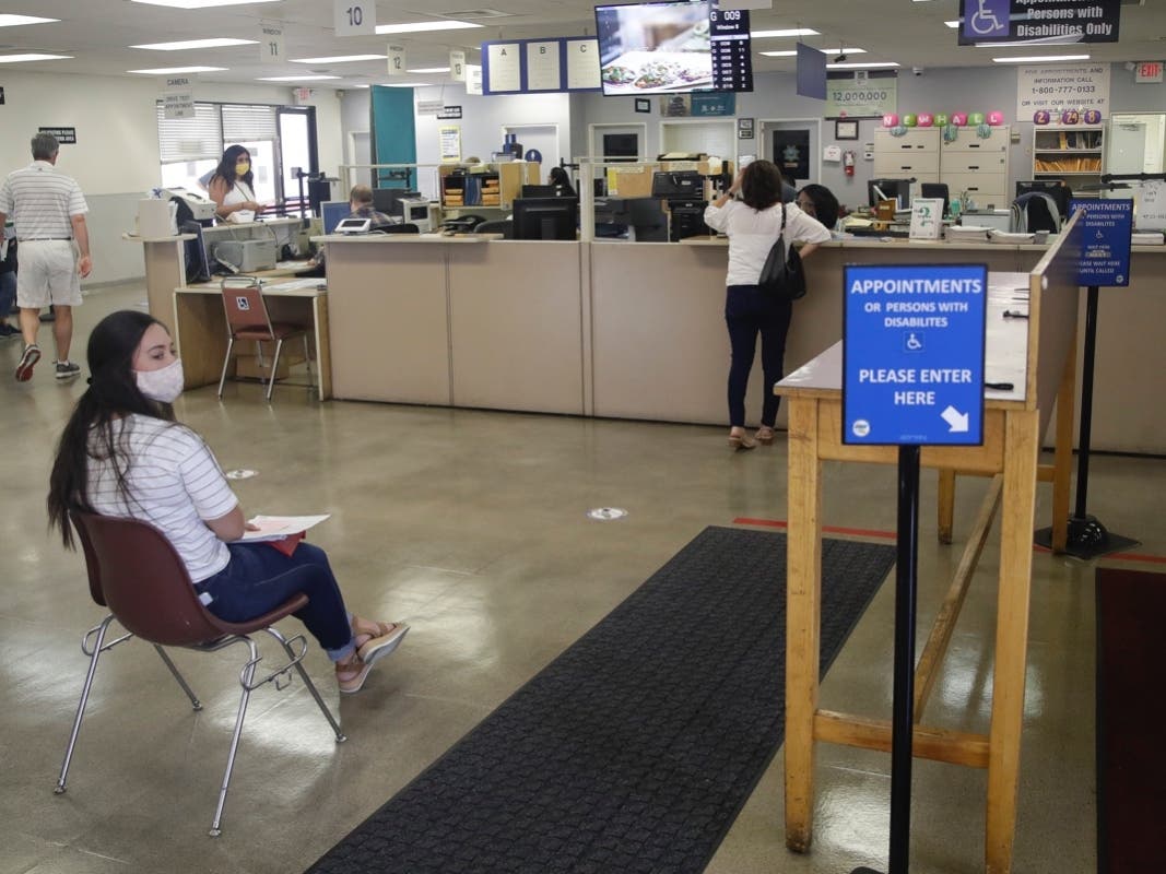 Customers practice social distance while waiting for services at a Department of Motor Vehicle office.