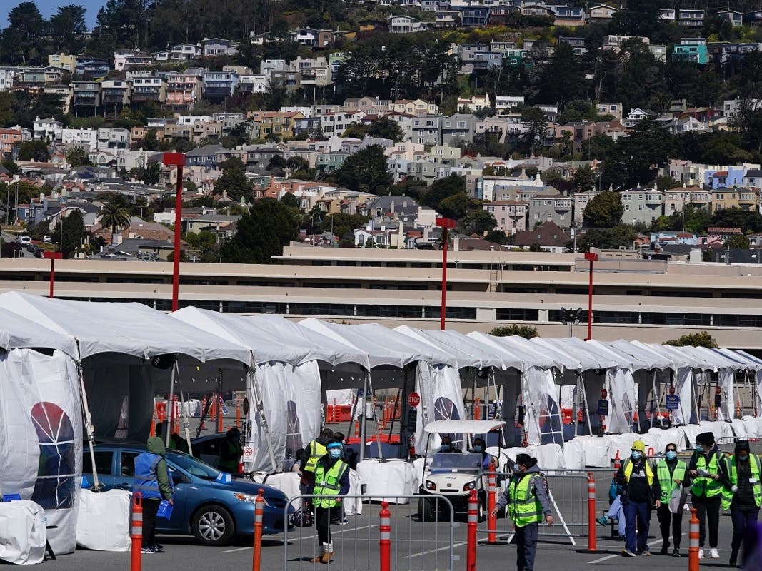 In this file photo Healthcare workers tend to people in cars at a drive up vaccination center at City College of San Francisco during the coronavirus pandemic