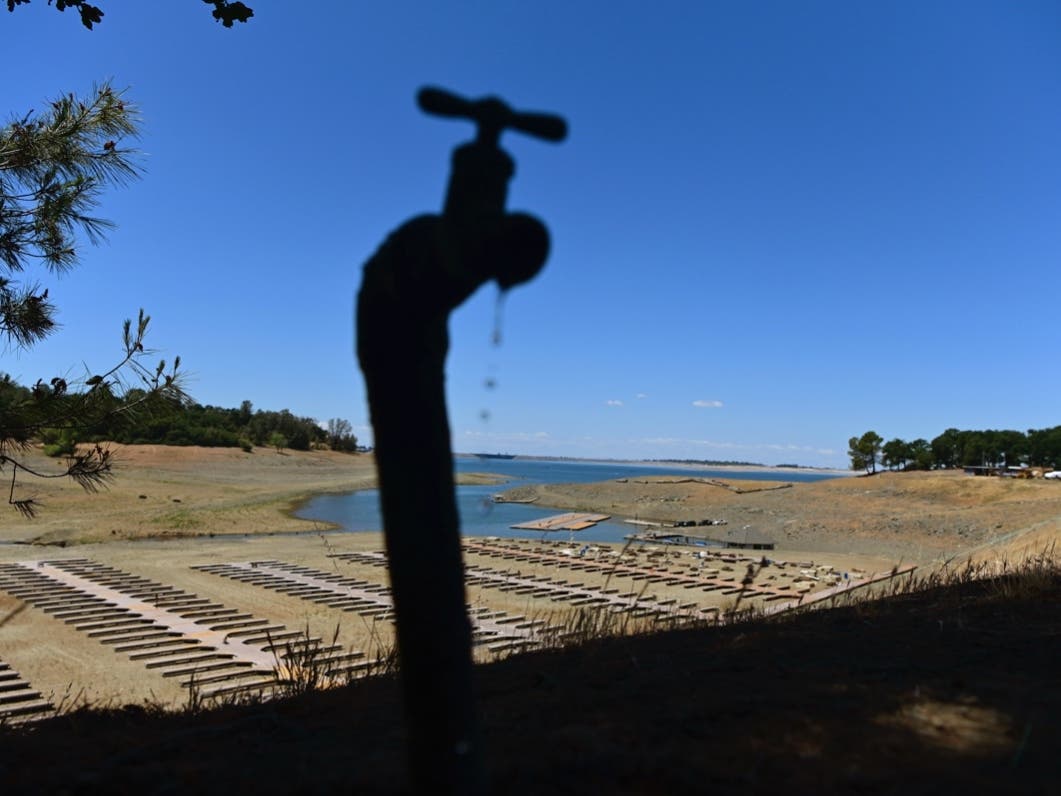 Water drips from a faucet near boat docks sitting on dry land at the Browns Ravine Cove area of drought-stricken Folsom Lake, in Folsom, Calif. 