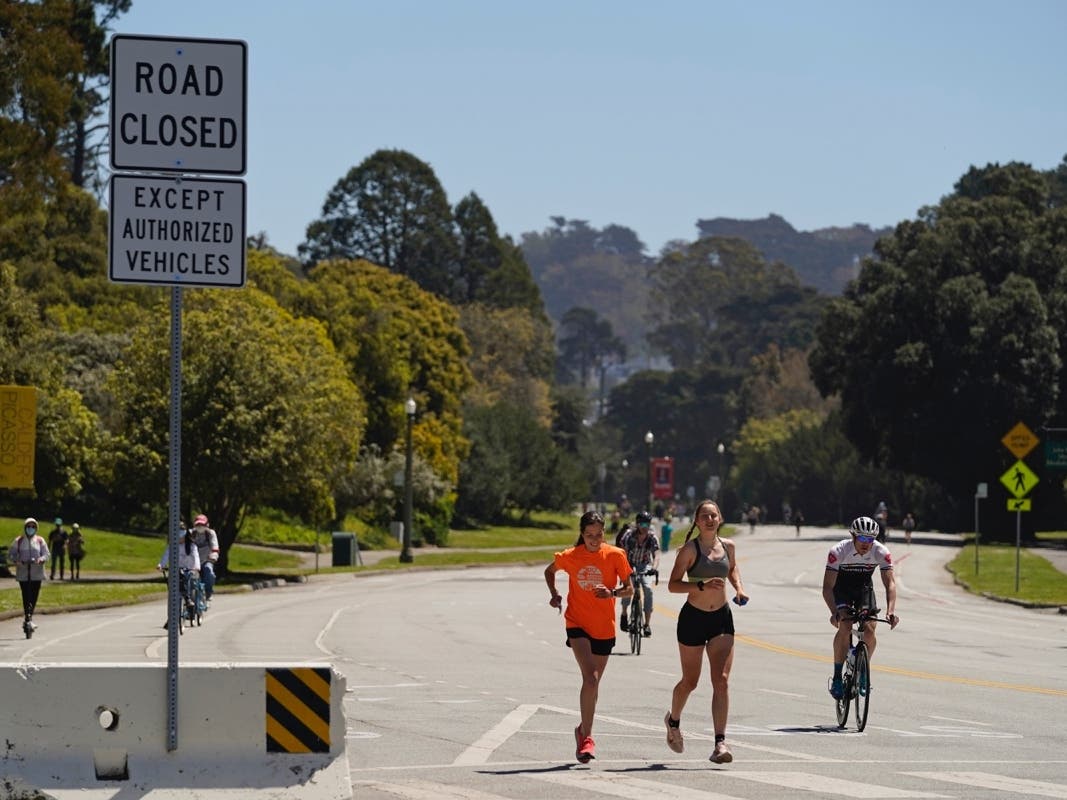 Joggers and cyclists make their way along car-free John F. Kennedy Drive in Golden Gate Park on April 28, 2021, in San Francisco. 