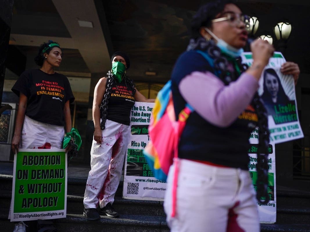 Abortion rights advocates hold signs at a protest in support of Lizelle Herrera in Los Angeles on April 14. 