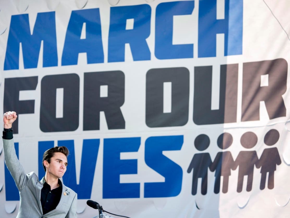 In this March 24, 2018 file photo, David Hogg, a survivor of the mass shooting at Marjory Stoneman Douglas High School in Parkland, Fla., raises his fist after speaking during the "March for Our Lives" rally in support of gun control in Washington. 