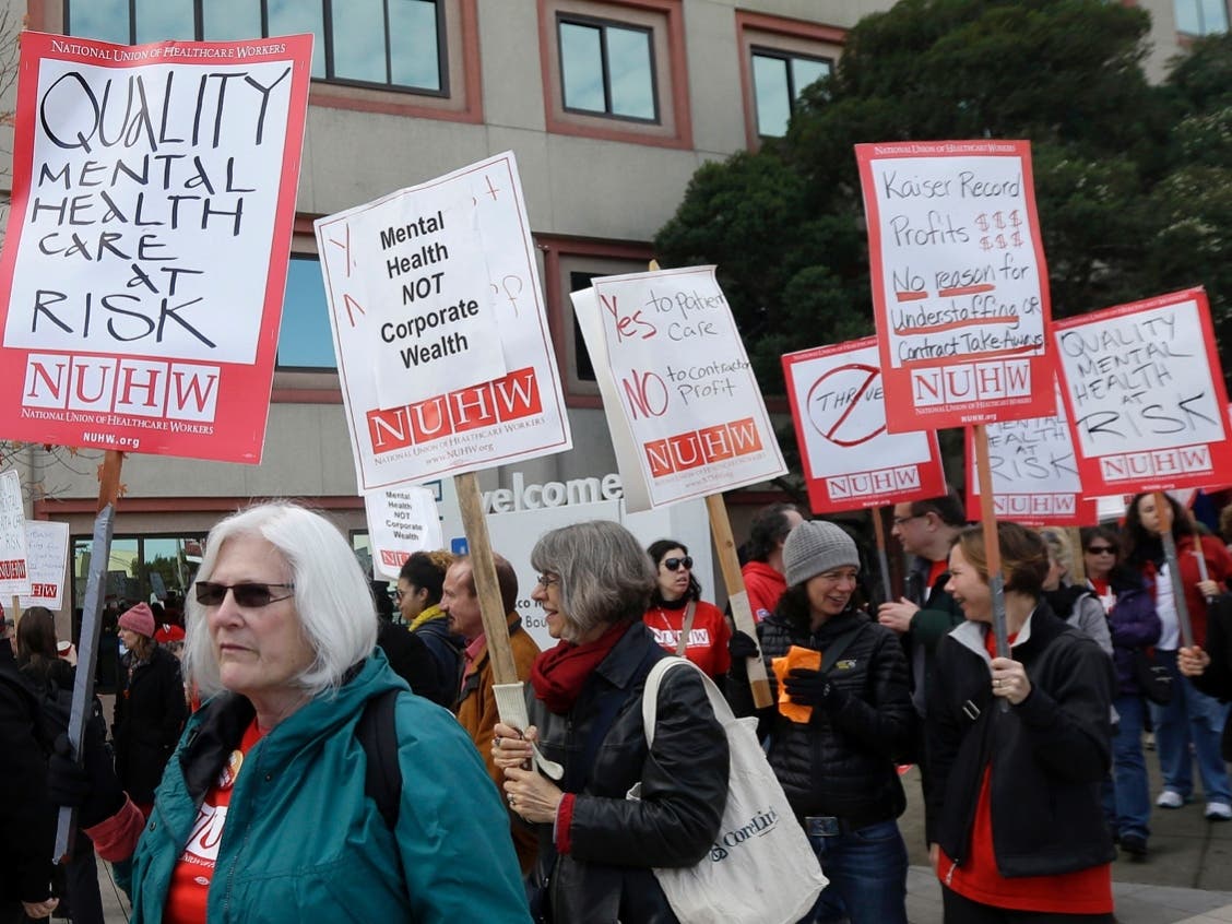 Protesters carry picket signs during a rally outside of a Kaiser Permanente facility in San Francisco, Monday, Jan. 12, 2015.