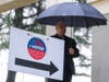A man holding an umbrella waits outside a voting station, Tuesday, Nov. 8, 2022, in Pacoima, Calif.