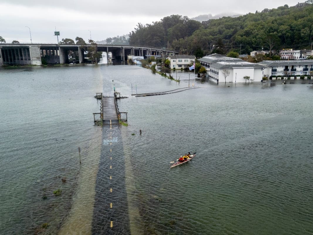 From front, brothers Connor and Brett Cardinal, and friend Eli Ferrell kayak towards a flooded Mill Valley-Sausalito Path during king tide in Mill Valley, Calif., Saturday, Jan. 3, 2026.