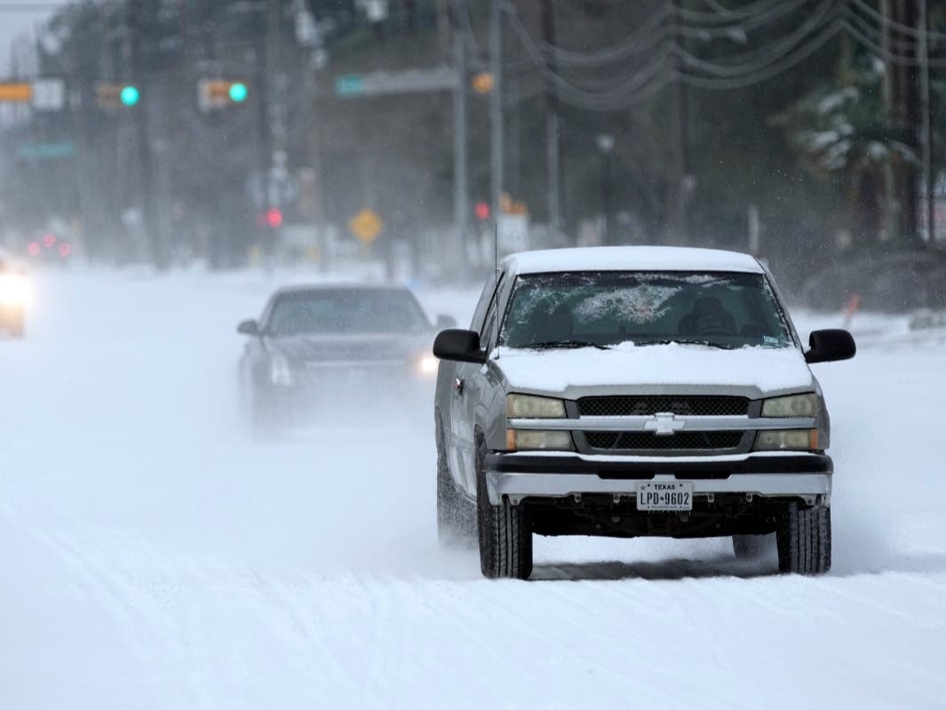Vehicles drive on snow and sleet covered roads Monday in Spring, Texas. A winter storm dropping snow and ice sent temperatures plunging across the southern Plains, prompting a power emergency in Texas.