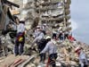 Search-and-rescue workers look for survivors in the rubble at the Champlain Towers South Condo in Surfside, which collapsed Thursday. 