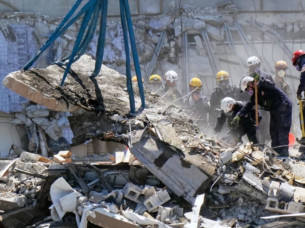 Crews work Sunday in the rubble at the Champlain Towers South Condo in Surfside, Fla. Eleven have been confirmed dead and 150 people are still unaccounted for after Thursday's collapse.