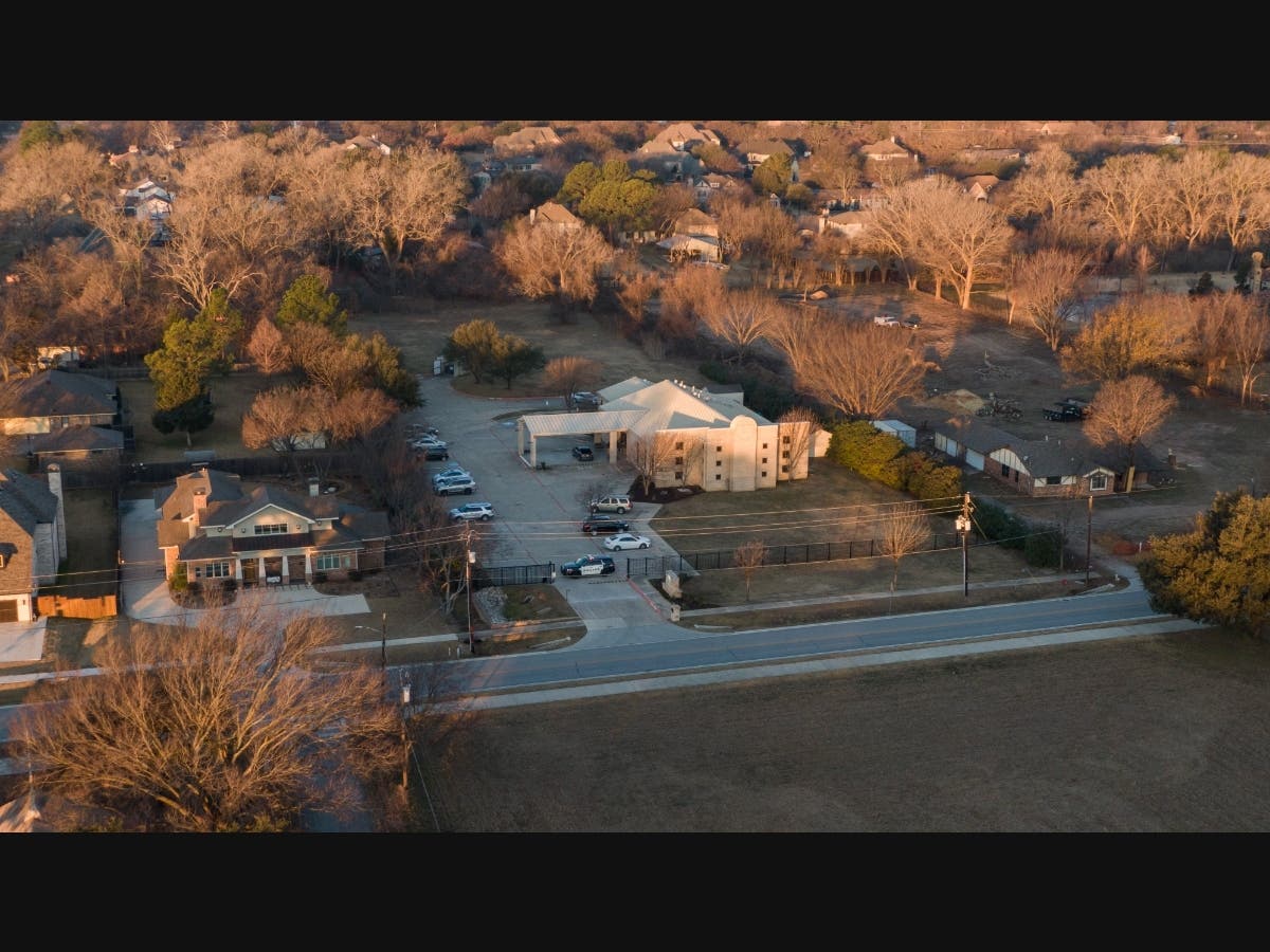 An aerial view of police standing in front of the Congregation Beth Israel synagogue Sunday in Colleyville, Texas. A man held hostages for more than 10 hours Saturday inside the temple.