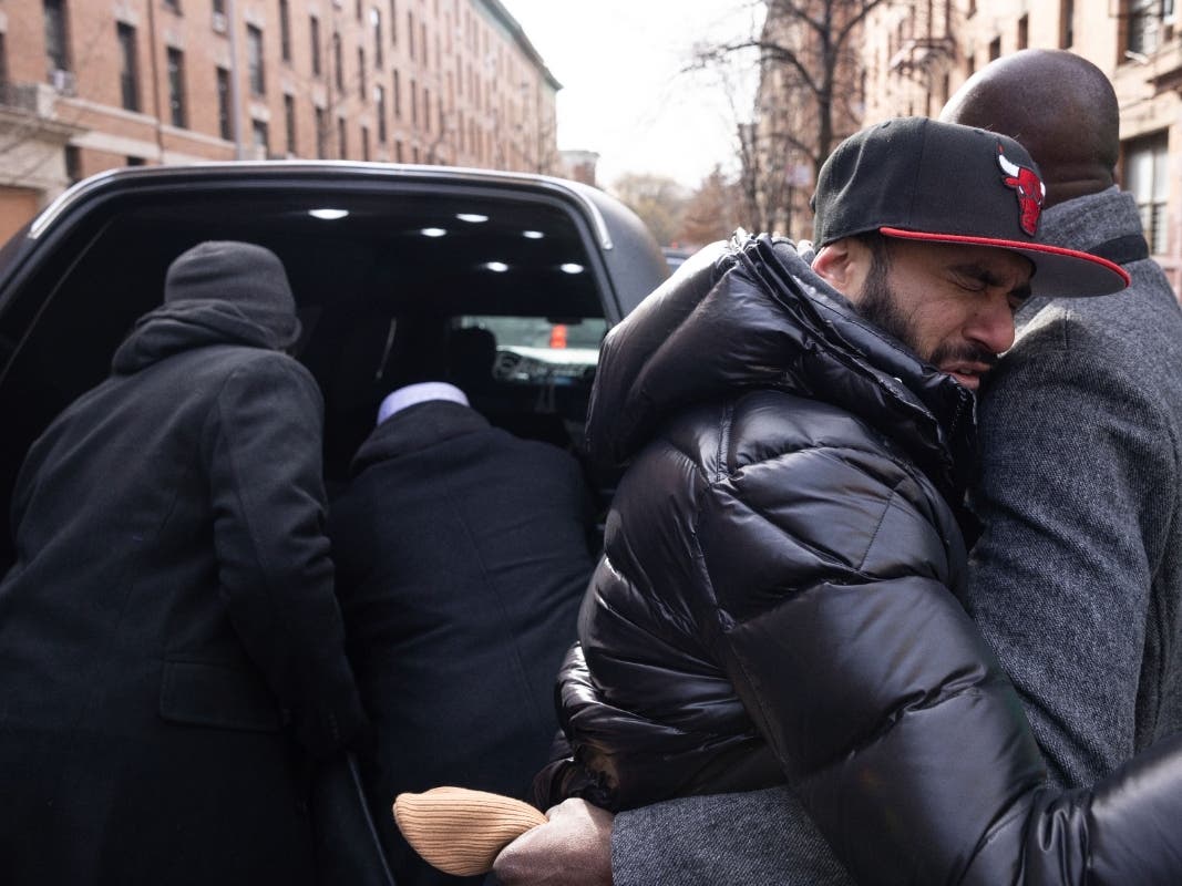 A person hugs the father of Ousmane Konteh, 2, in front of a hearse after the funeral service for victims from the apartment building which suffered the city's deadliest fire in three decades, at the Islamic Cultural Center for the Bronx on Sunday.