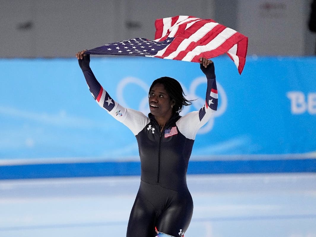 Erin Jackson of the United States hoists an American flag after winning the gold medal in the speedskating women's 500-meter race at the 2022 Winter Olympics, Sunday in Beijing.