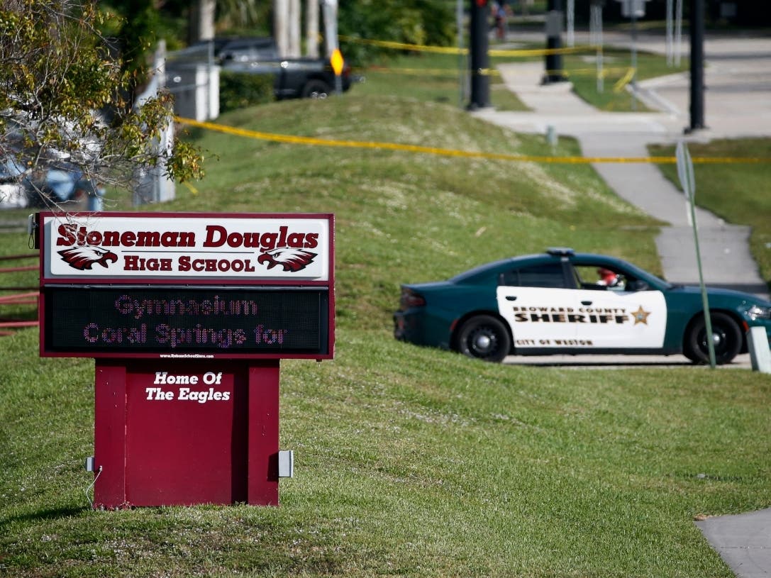 Law enforcement officers block off the entrance to Marjory Stoneman Douglas High School Feb. 15, 2018, in Parkland, Fla., following a shooting at the school. The Department of Justice settled 40 civil suits related to the shooting for $127.5 million.