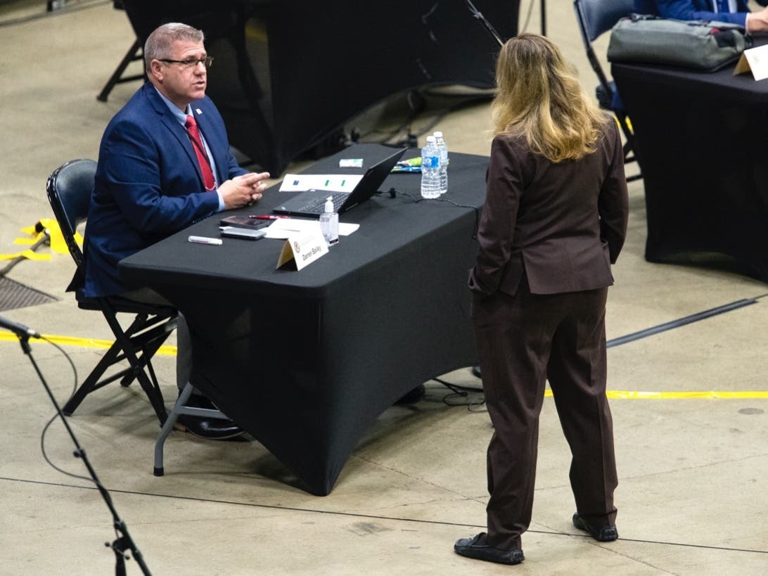 Darren Bailey (R-Louisville) speaks with a colleague before session begins at the Bank of Springfield Center in Springfield, Ill., where the Illinois House of Representatives were preparing to conduct their spring session May 20, 2020.