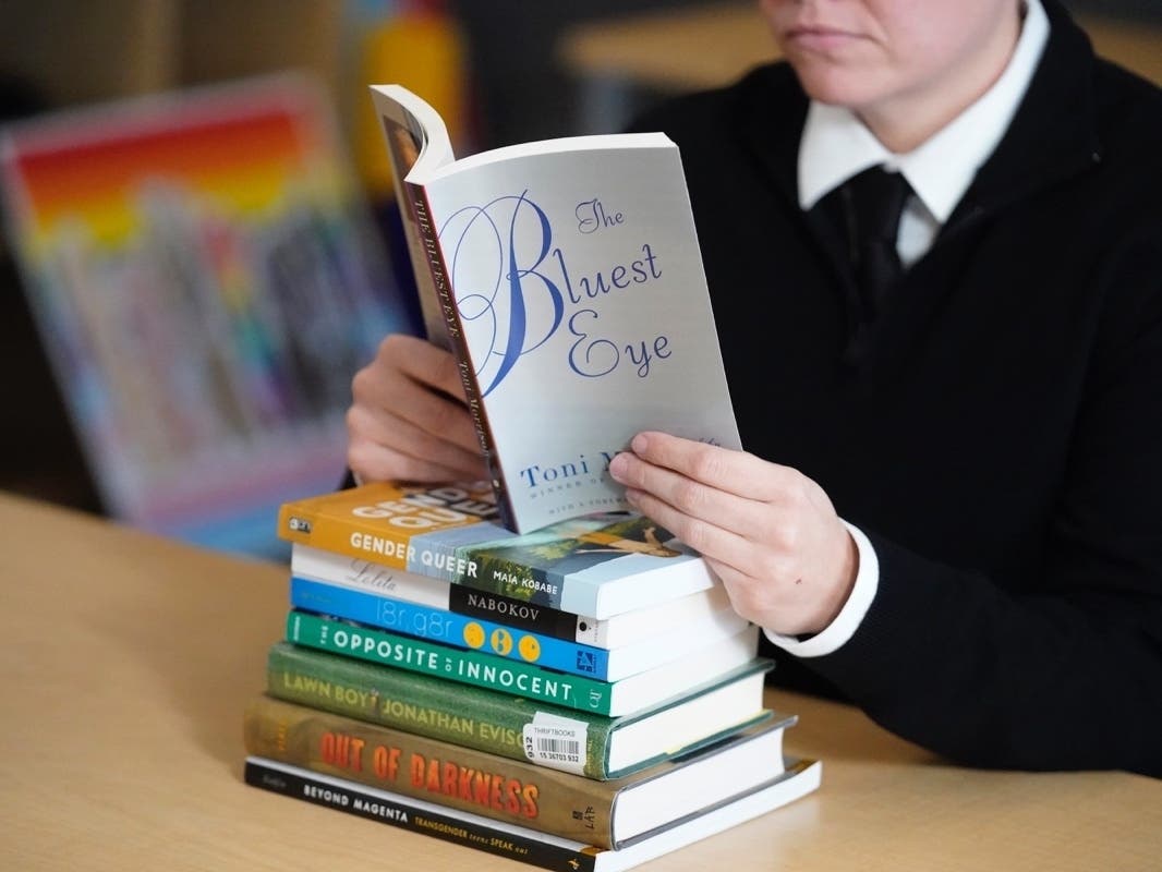 FILE - Amanda Darrow, director of youth, family and education programs at the Utah Pride Center, poses with books, including "The Bluest Eye," by Toni Morrison. Morrison's book is one of several some Central Bucks parents want out of district libraries.