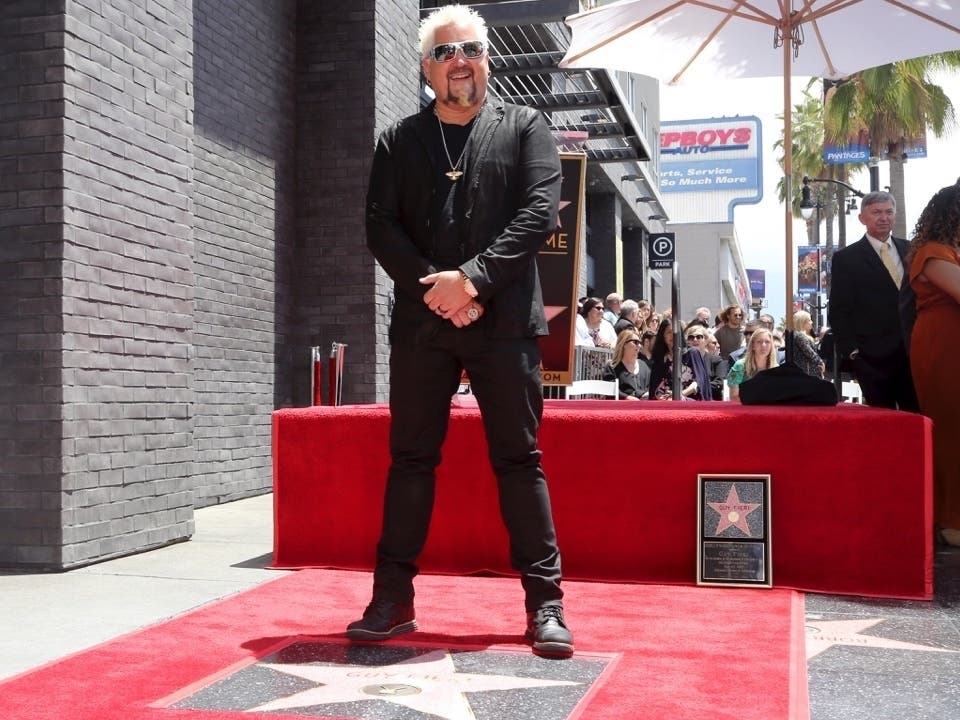 Guy Fieri poses atop a star following a ceremony honoring him with a star at the Hollywood Walk of Fame on Wednesday, May 22, 2019, in Los Angeles.