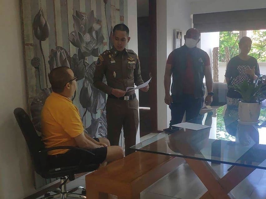 Peter Coker Jr., left, is issued search warrants from police at his villa on the southern resort island of Phuket, Thailand, Jan. 11, 2023.