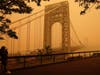 A man talks on his phone as he looks through the haze at the George Washington Bridge in Fort Lee, N.J., Wednesday, June 7, 2023. 