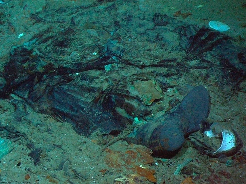 FILE - This 2004 photo provided by the Institute for Exploration, Center for Archaeological Oceanography/University of Rhode Island/NOAA Office of Ocean Exploration, shows the remains of a coat and boots in the mud on the sea bed near the Titanic's stern.