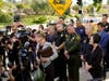 Laguna Woods Mayor Carol Moore, front left at podium, and Orange County Board of Supervisor, Lisa Barlett, right, surrounded by law enforcement officers, hold a press conference outside the grounds of Geneva Presbyterian Church in Laguna Woods Sunday.