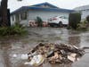 Ruben Gomez digs away some of the mud and flood debris that engulfed his parents' home in the previous rainstorm as more rain falls, Thursday, Feb. 1, 2024, in San Diego.