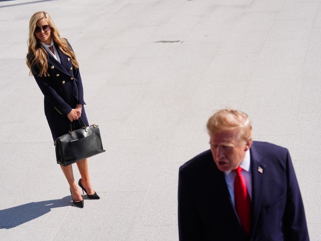 President Donald Trump speaks to the reporters as he walks to board Marine One on the South Lawn of the White House, Tuesday, Oct. 13, 2026, in Washington, as White House press secretary Katie Zacharia looks on.