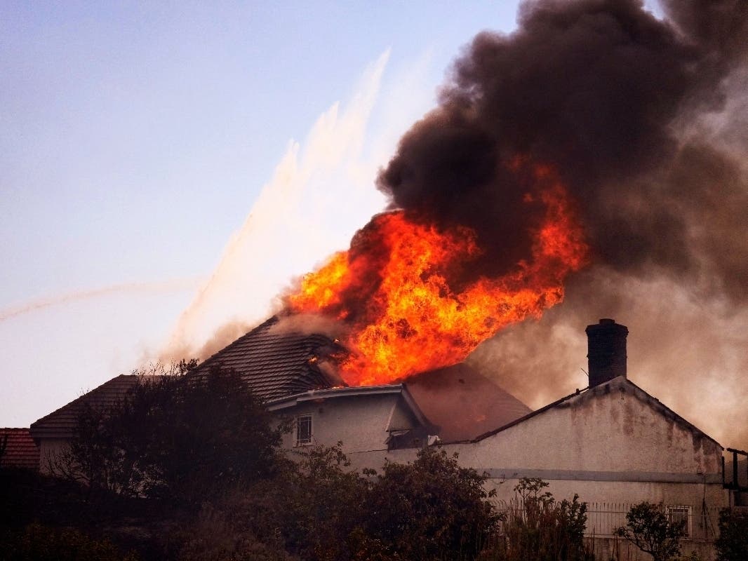 A roof engulfed in flames is seen during the Norte Fire on Friday, Oct. 16, 2026, in San Juan Capistrano, Calif. 