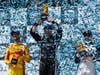 From left, second place winner driver Romain Grosjean of France, first place winner driver Josef Newgarden of United States, and third place winner driver Álex Palou of Spain hold their trophies after a race at the Grand Prix in 2022.