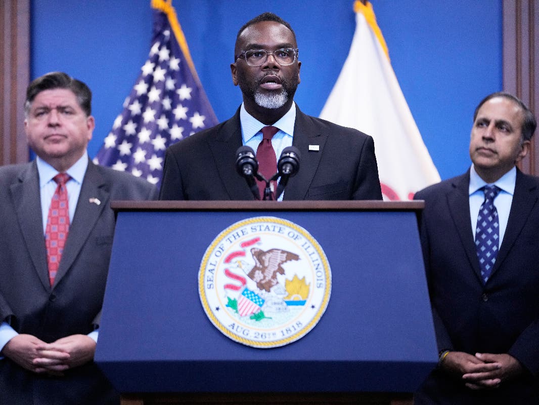 Chicago Mayor Brandon Johnson, center, speaks as Governor JB Pritzker, left, and US Representative Raja Krishnamoorthi listen to him at a news conference in Chicago, Monday, Oct. 6, 2025.