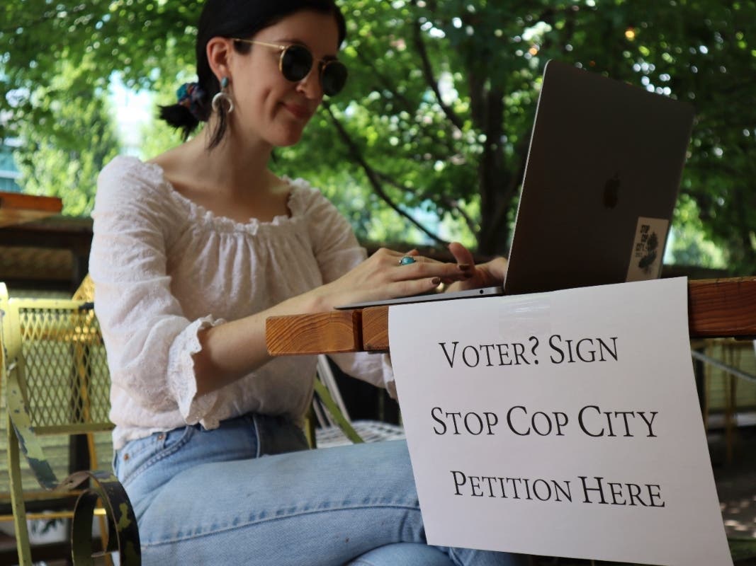 Activist Hannah Riley works on her laptop at Muchacho, a local taco restaurant, while gathering signatures from fellow voters, in Atlanta, Thursday, July 13, 2023.