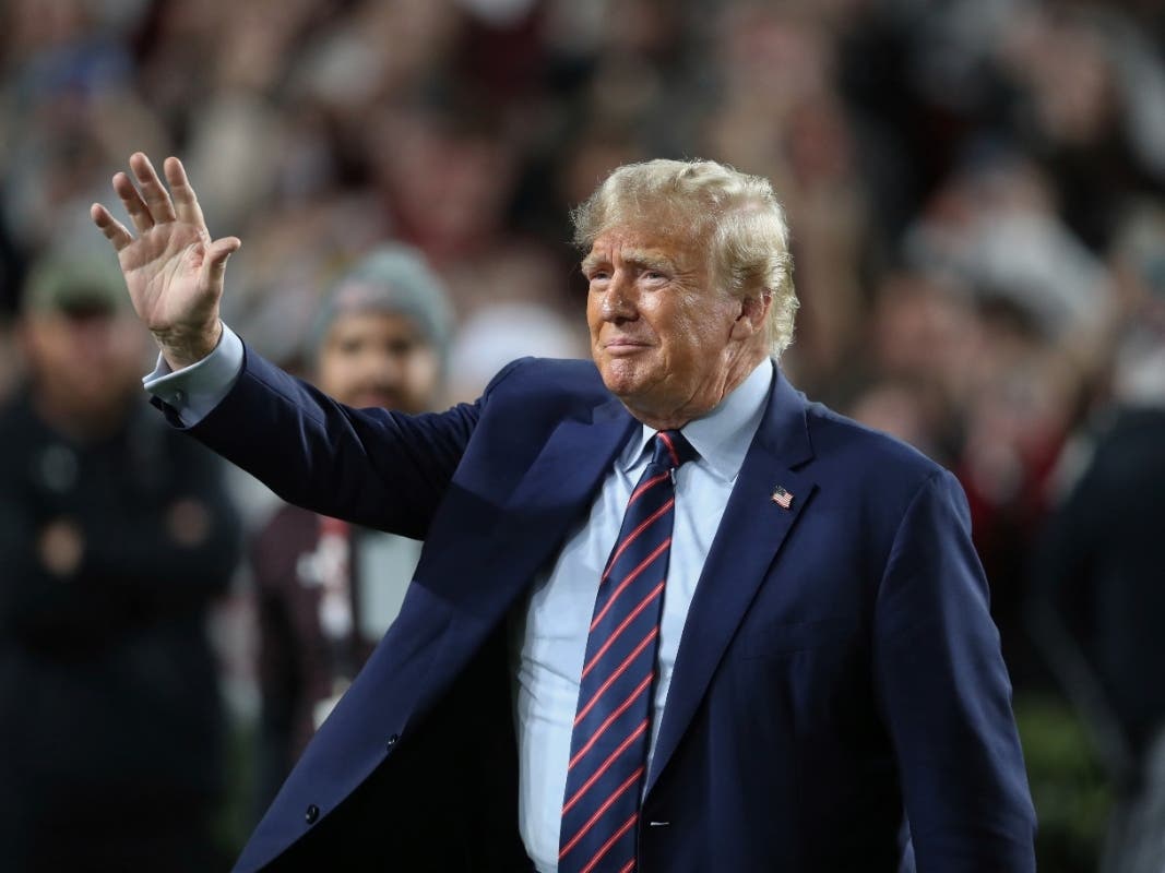 Republican presidential candidate and ormer President Donald Trump waves during halftime of an NCAA college football game between South Carolina and Clemson, Saturday, Nov. 25, 2023, in Columbia, S.C.