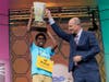 Bruhat Soma, 12, of Tampa, Fla., accepts the trophy from E.W. Scripps Company president and CEO Adam Symson after winning the Scripps National Spelling Bee, in Oxon Hill, Md., Thursday, May 30, 2024.