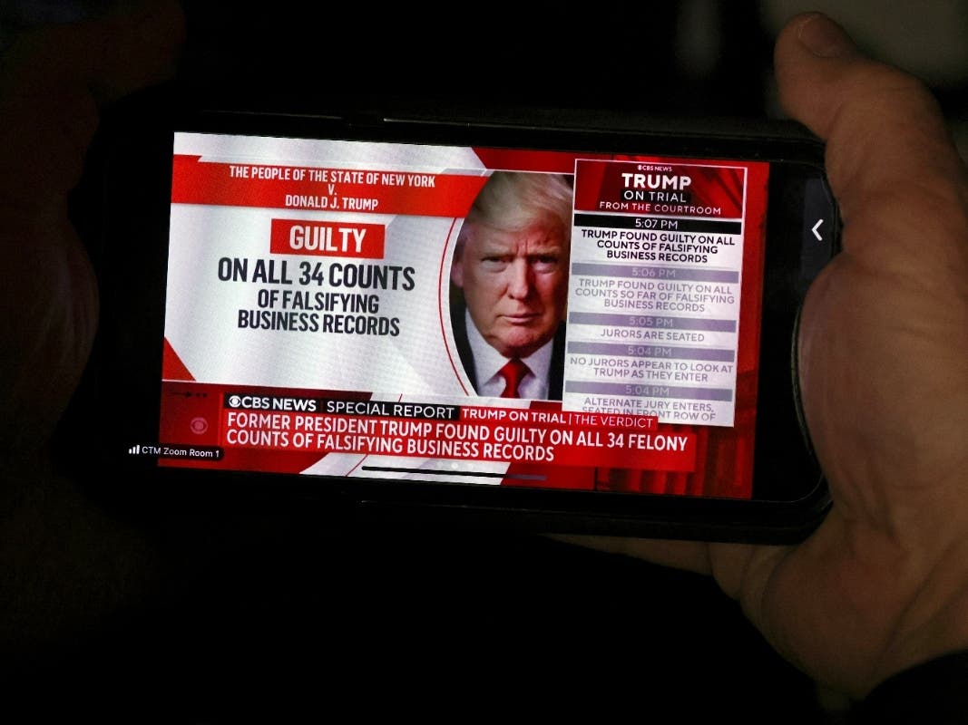 A member of the media looks at news of former President Donald Trump on his phone after the conclusion of Trump's hush money trial, in New York, Thursday, May 30, 2024.