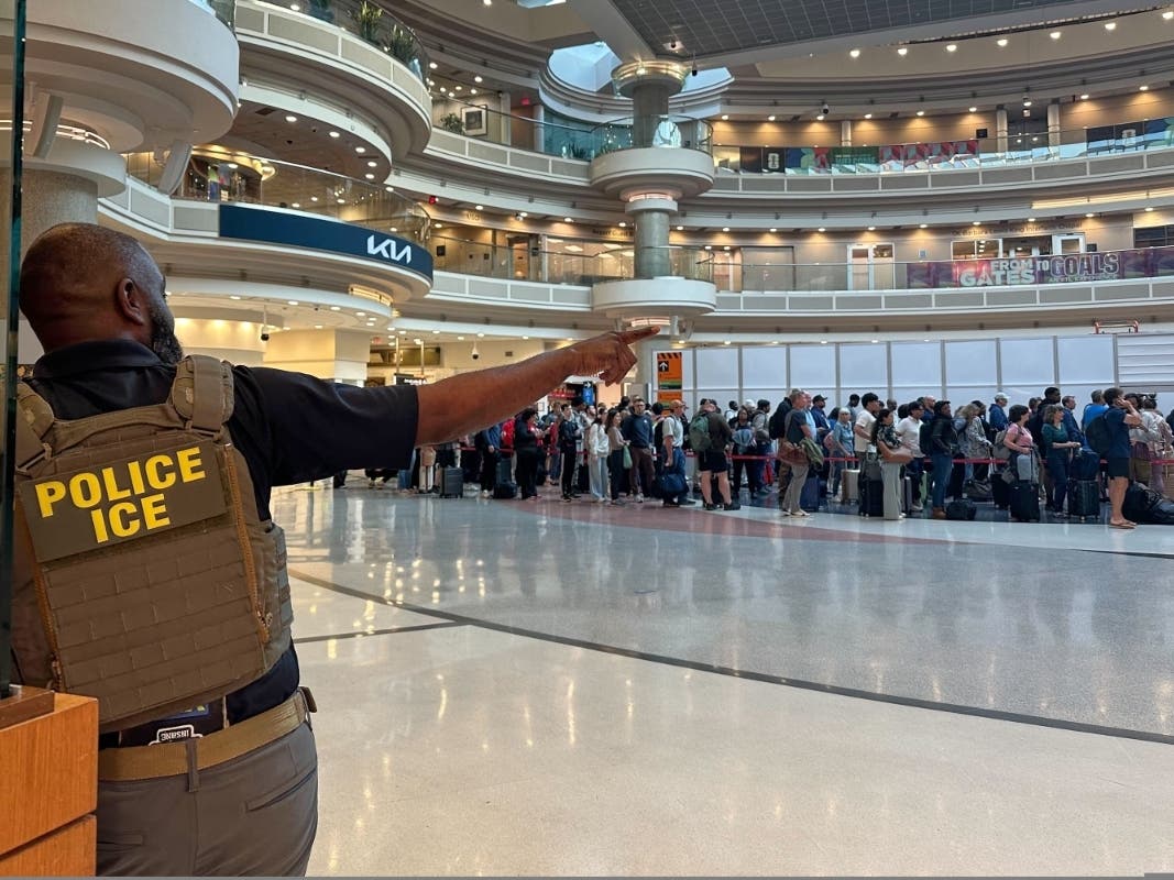 A federal immigration agent is seen as people wait in a TSA line at the Hartsfield-Jackson Atlanta International Airport, Monday, March 23, 2026, in Atlanta.
