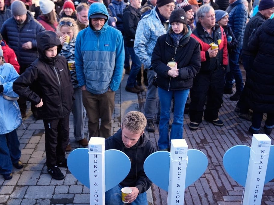A boy writes a message on a memorial for the 9 people who died in an avalanche in California's Sierra Nevada, Sunday, Feb. 22, 2026, in Truckee.