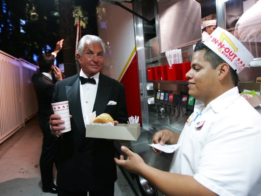 George Hamilton enjoys an In-N-Out burger outside the Vanity Fair Oscar Party at the Sunset Tower in Los Angeles, Sunday, Feb. 27, 2011.