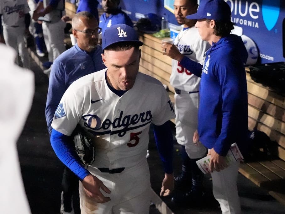 Los Angeles Dodgers' Freddie Freeman leaves the baseball game after falling into the visitors dugout while trying to catch a foul ball hit by Kansas City Royals' Isaac Collins in the eighth inning, Wednesday, Aug. 12, 2026, in Los Angeles.