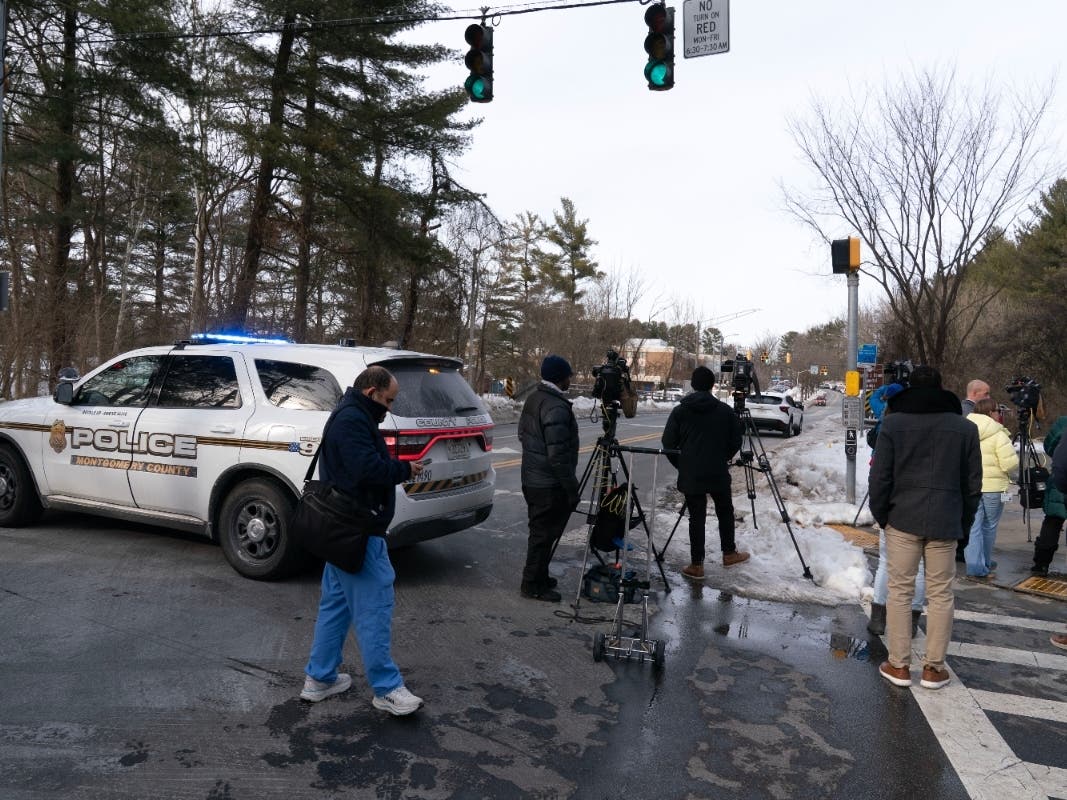 Montgomery County Police block the street as people wait outside Thomas S. Wootton High School for students in Rockville, Monday, Feb. 9, after a student was shot inside the school.