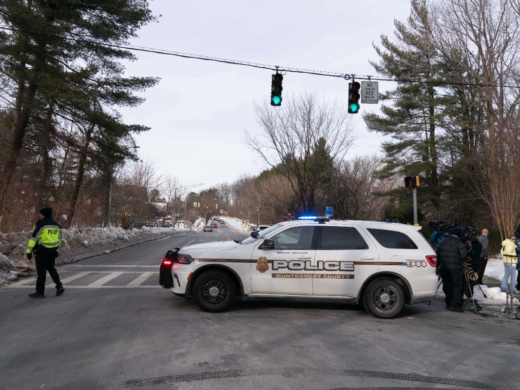 A Montgomery Police officer blocks the road as people wait outside Thomas S. Wootton High School for students in Rockville on Monday, Feb. 9, 2026, after a person was shot inside the school.