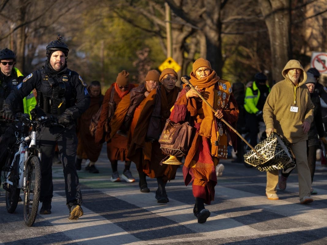 Buddhist monks who are participating in a Walk For Peace walk through a neighborhood on Tuesday, Feb. 10, 2026, in Washington.