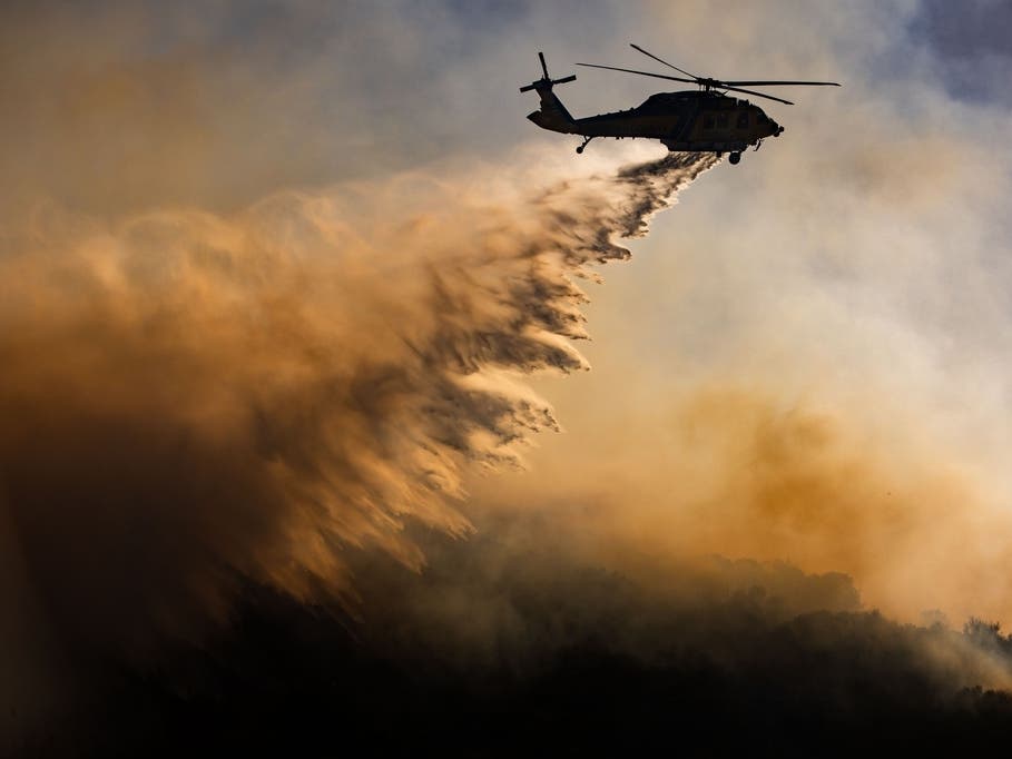 A helicopter drops water on the Sandy Fire, Monday, May 18, 2026, in Simi Valley, Calif