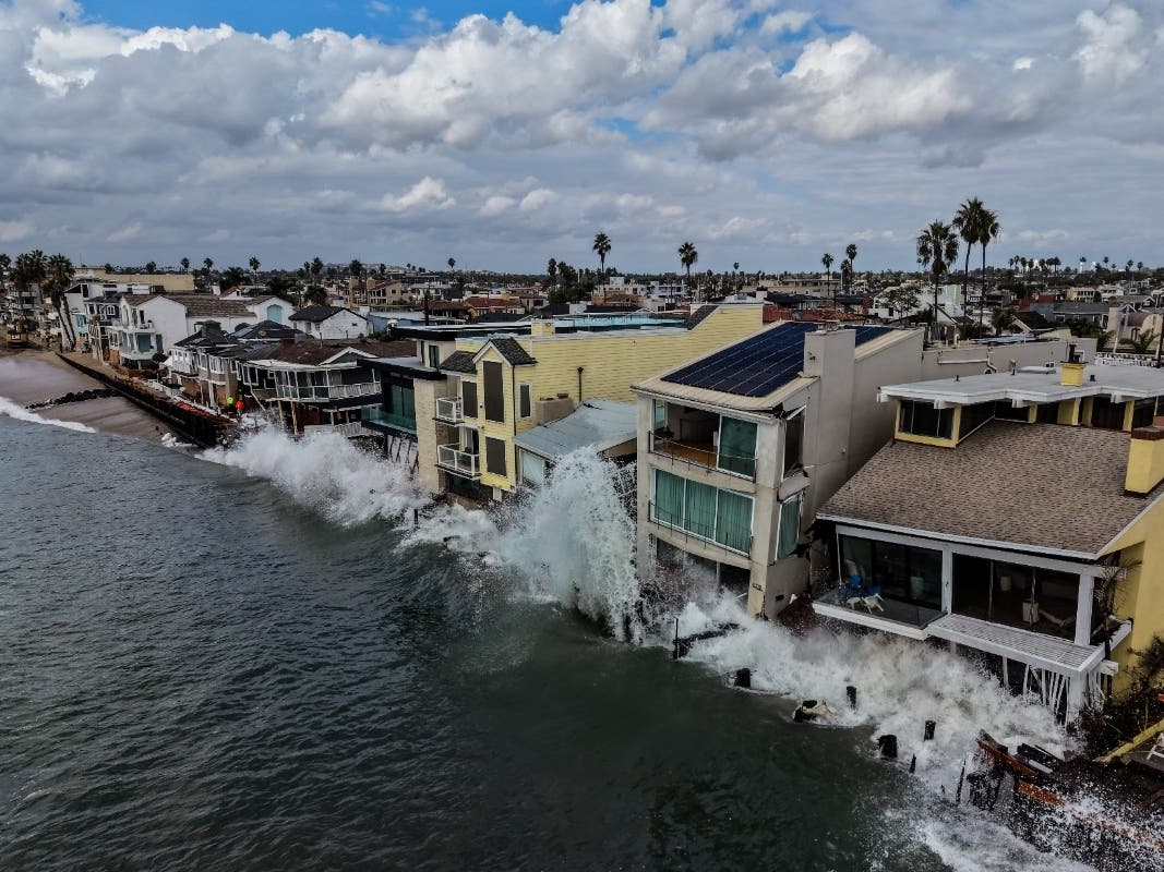 Powerful surf crashes against beachfront homes along the Long Beach Peninsula, where severe coastal erosion has prompted evacuations and a multimillion-dollar recovery effort.
