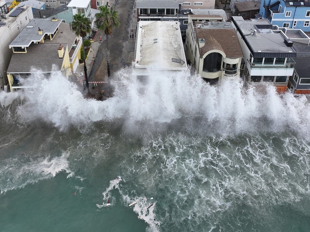 Waves batter a walkway in front of Long Beach homes on Oct. 10, 2026, as Tropical Storm Rachel approaches. Another storm now threatens the already damaged coastline with heavy rain, dangerous surf and possible flooding.