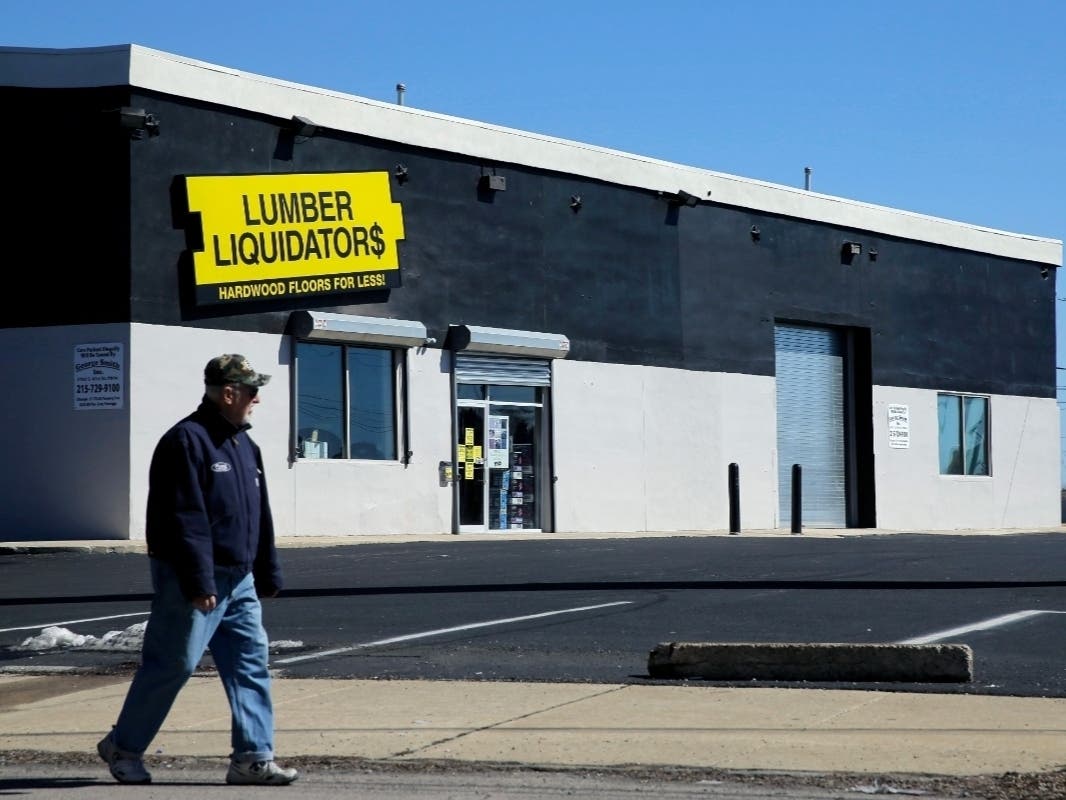 In this March 12, 2015 file photo, a man walks past a Lumber Liquidators store. The company announced the abrupt closure of all stores this week.