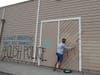 A worker for La Mesa Lumber paints over graffiti Sunday after a protest over the death of George Floyd. Protests were held in U.S. cities over the death of Floyd, a black man who died after being restrained by Minneapolis police.