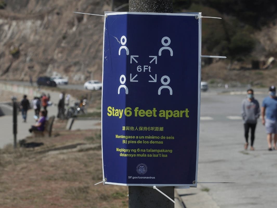 A sign advising social distance is posted at a closed parking lot to Ocean Beach during the coronavirus outbreak, in San Francisco, Sunday, July 5, 2020. 