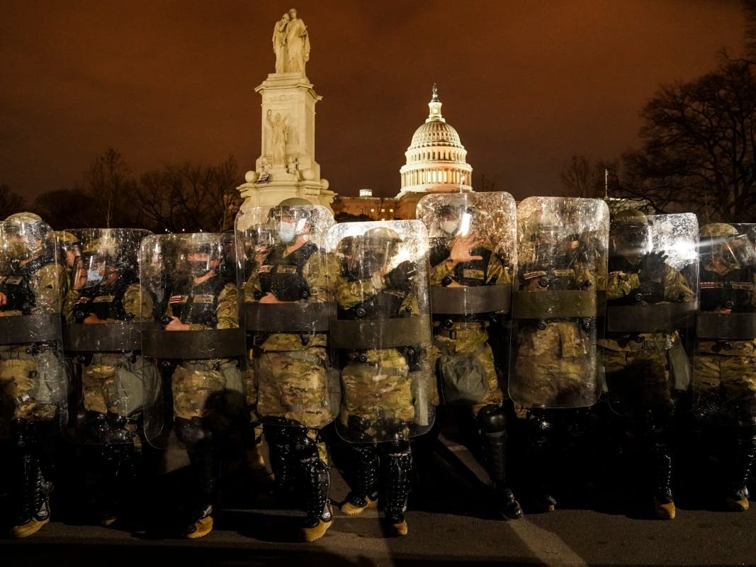 District of Columbia National Guard stand outside the Capitol, Wednesday night, Jan. 6, 2021, after a day of rioting protesters. 