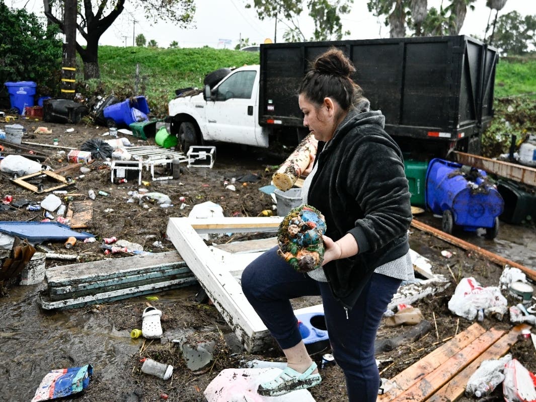 Marlene Sanchez-Barriento salavages items behind her home damaged by flooding, Tuesday, Jan. 23, 2024, in. Sanchez-Barriento's home was damaged when flood waters rushed though her home on Monday, Jan. 22.