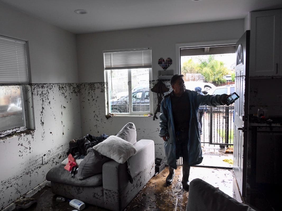 Tony Blas points to the water line inside his home that flooded during a rain storm Monday, Jan. 22, 2024, in San Diego.