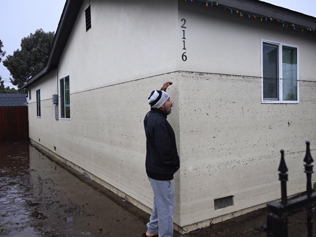 Juan Gonzales gestures to the waterline of a flooded home during a rain storm Monday, Jan. 22, 2024, in San Diego.